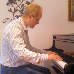 A photo of John Saxon playing the piano.