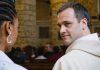 A male clergy member looking at a woman in a church.