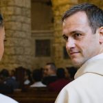 A male clergy member looking at a woman in a church.
