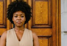 What the Church Taught Me About Womanhood—and What Jesus Unlearned A photo of a strong woman standing in front of the doors to a church.